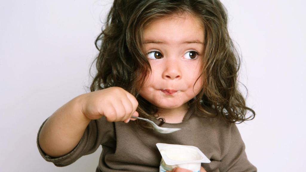 Niña comiendo lácteos.
