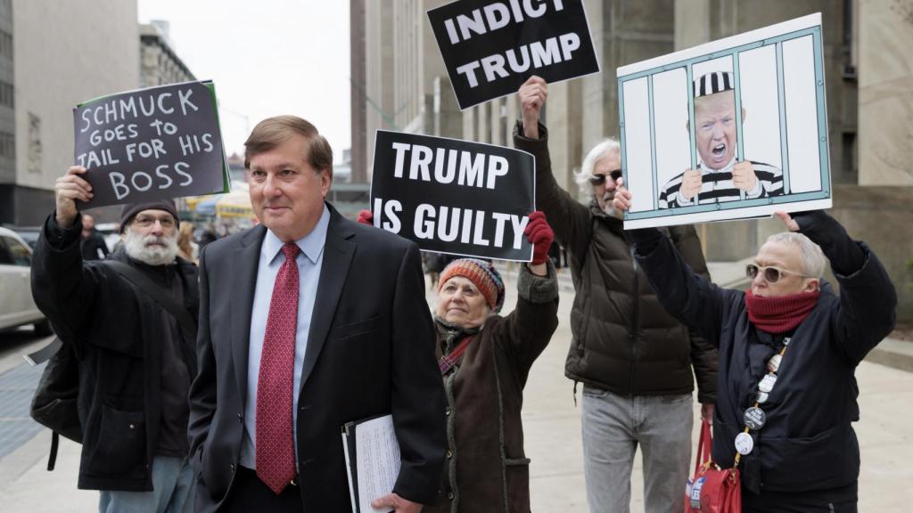 Allen Weisselberg, es seguido por manifestantes