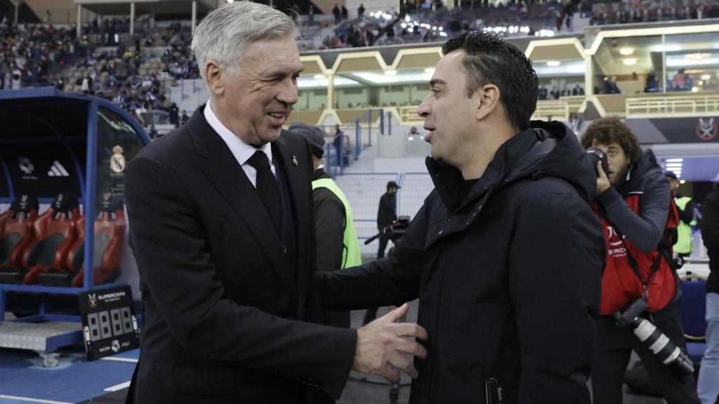 Ancelotti y Xavi se saludan.