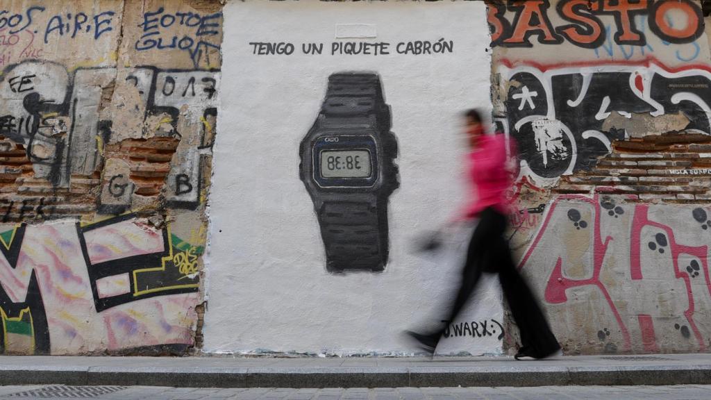 Una persona pasa ante un grafiti del grafitero J.Warx que alude al último éxito de la cantante colombiana Shakira