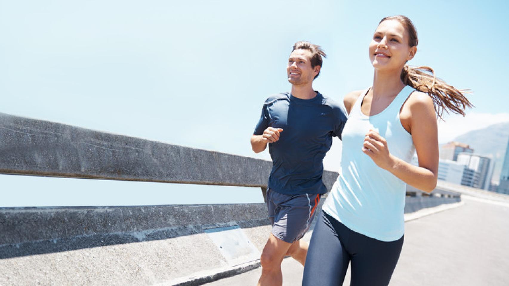 Una pareja sale a correr por un paseo marítimo