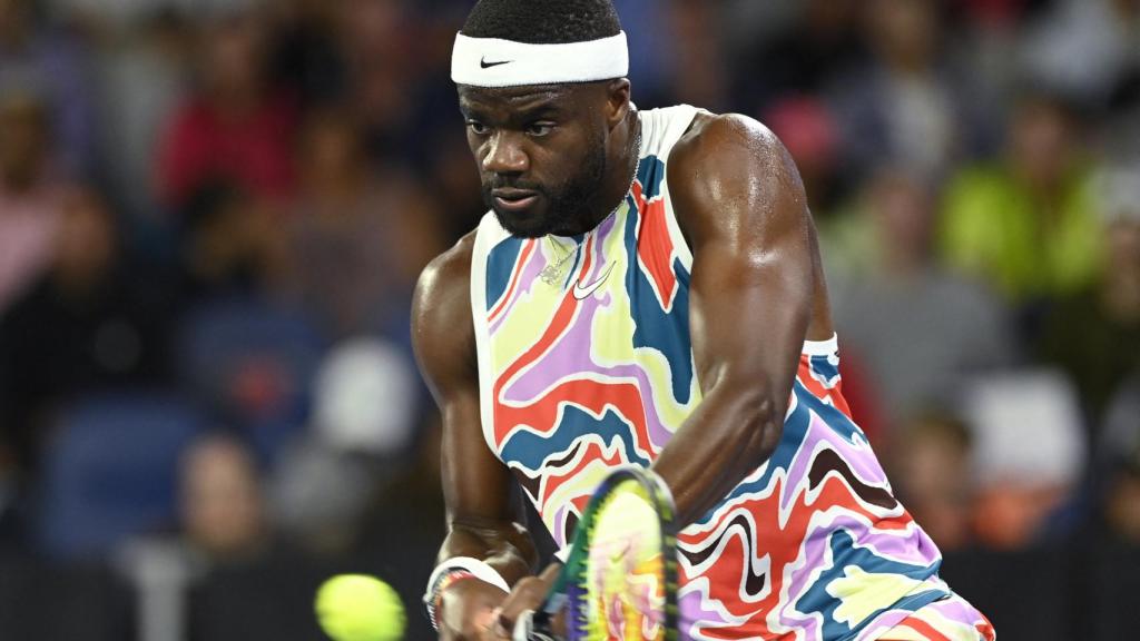 Tiafoe devuelve un revés.
