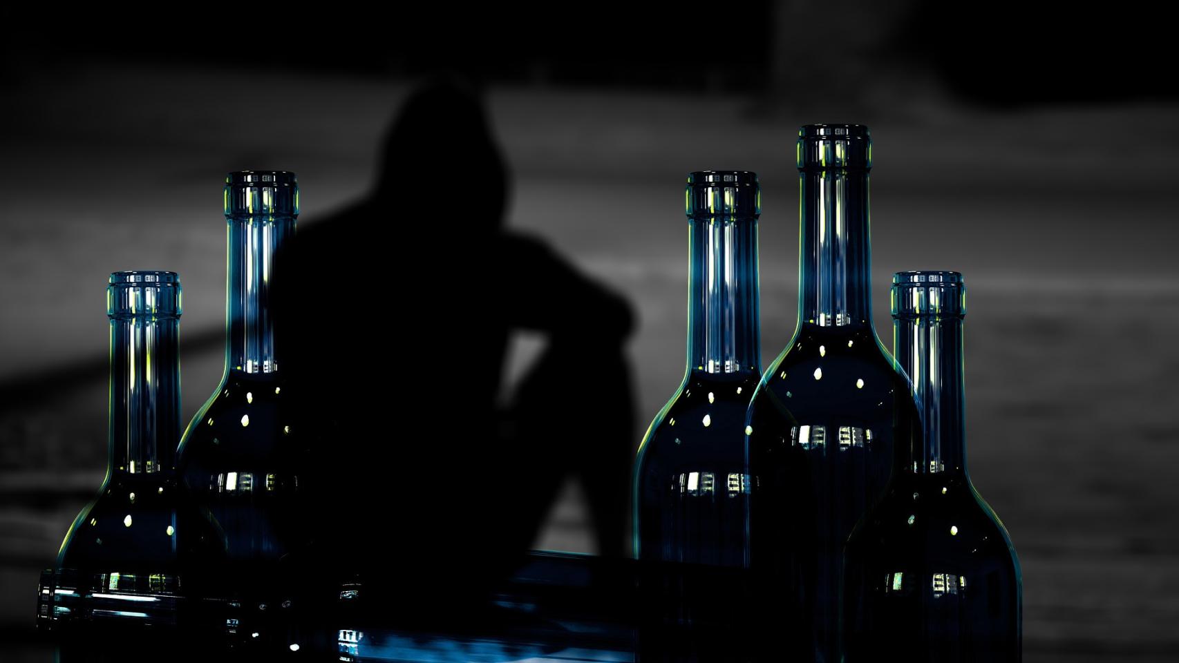 Imagen de archivo de un hombre con botellas de alcohol.