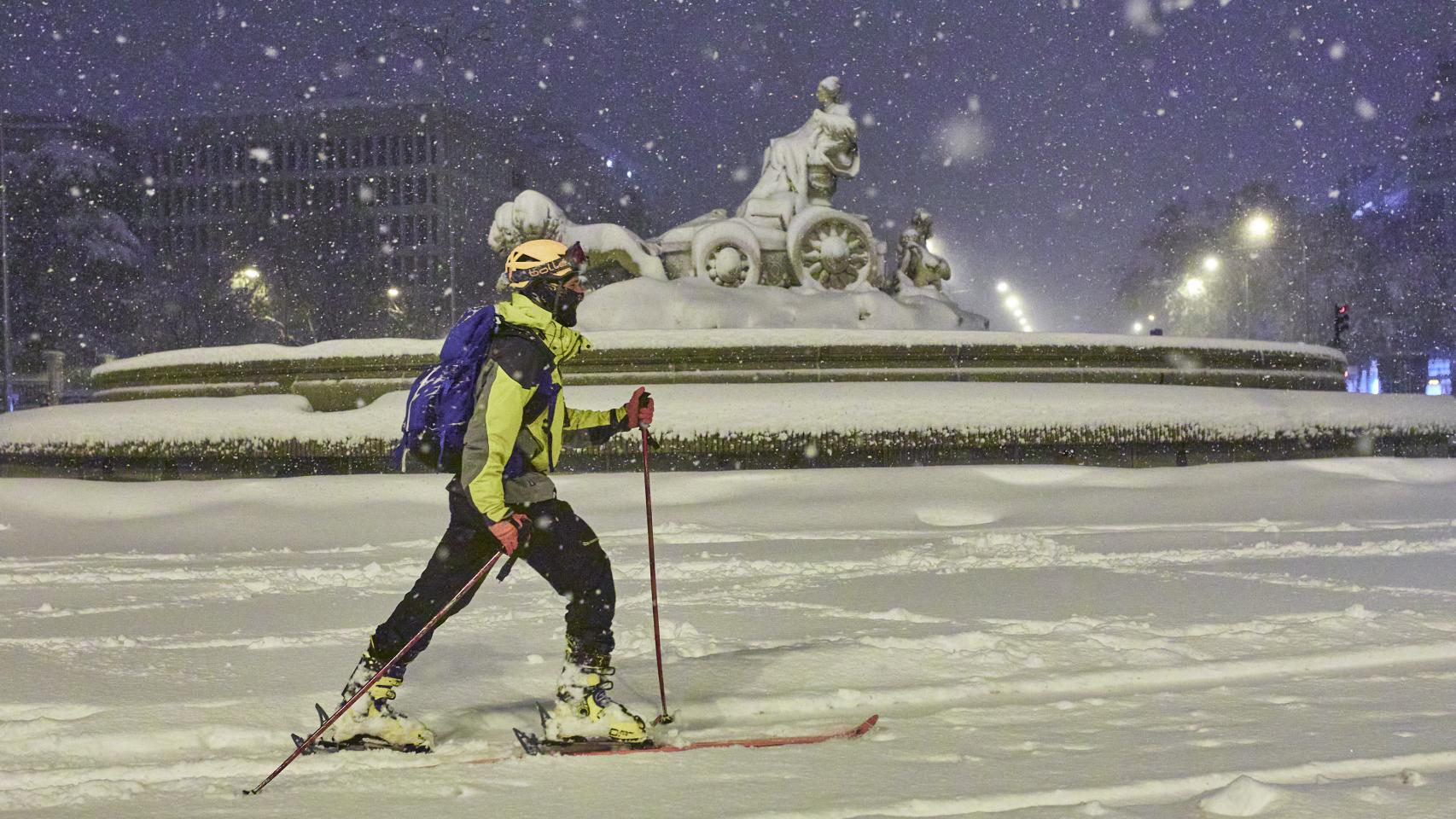 Una persona avanza con esquíes junto a la fuente de Cibeles, cubierta de nieve por la borrasca Filomena a 9 de enero de 2021