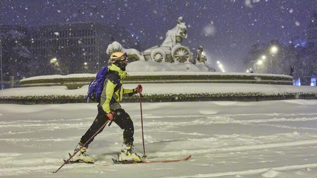 Una persona avanza con esquíes junto a la fuente de Cibeles, cubierta de nieve por la borrasca Filomena a 9 de enero de 2021