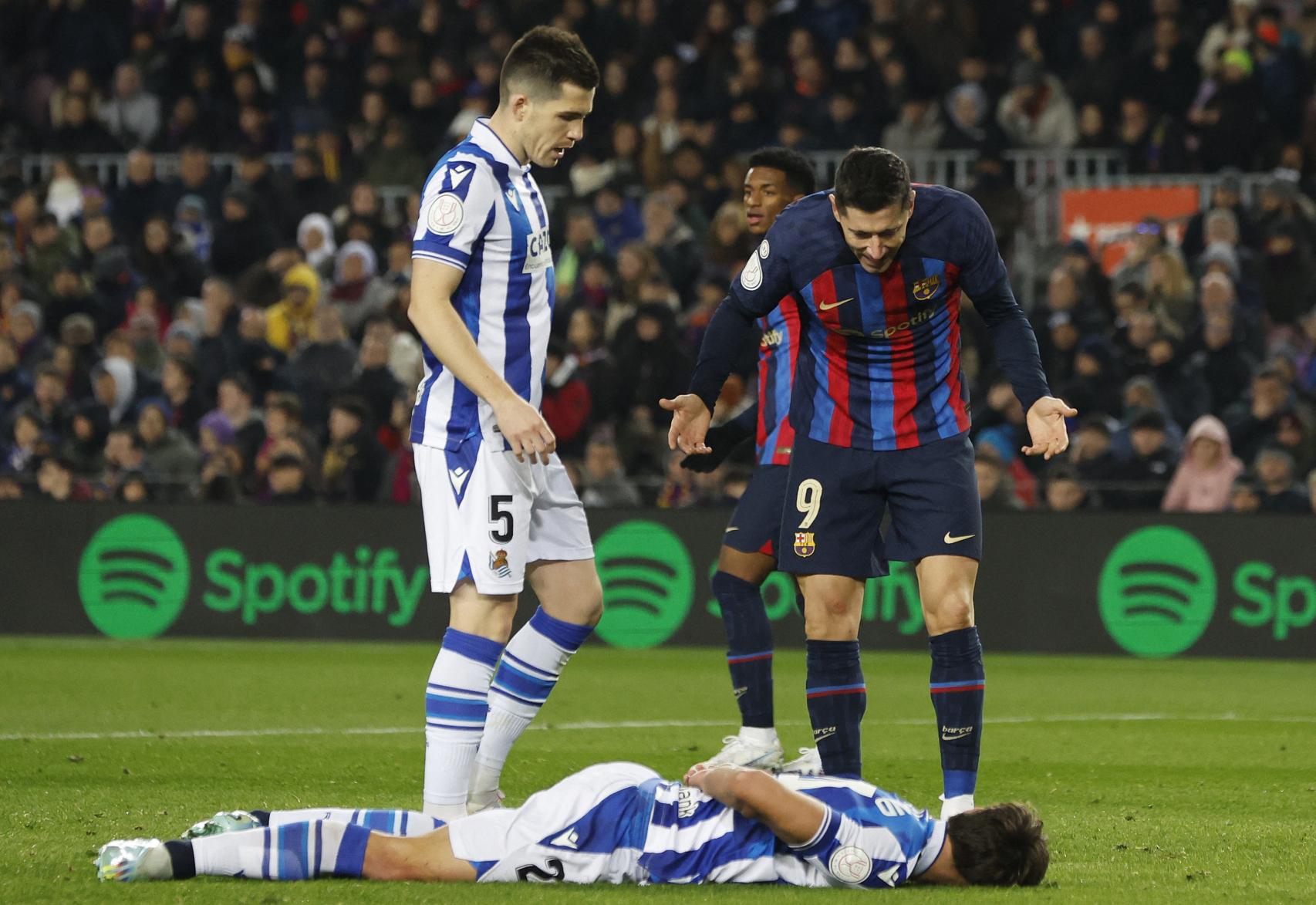 Lewandowski le pide explicaciones a un jugador de la Real Sociedad en el suelo.