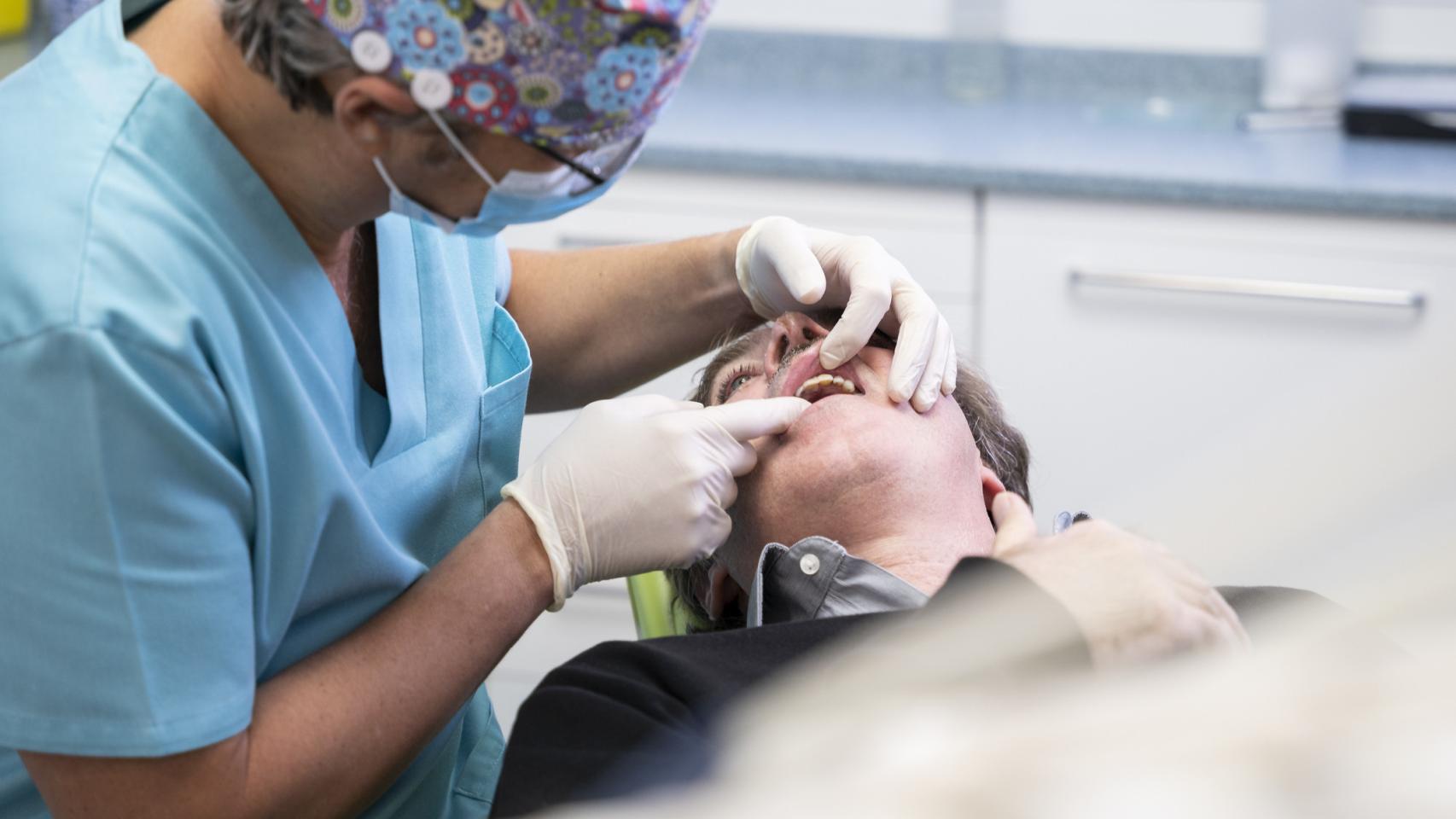 Dentista examinando a un paciente en una clínica