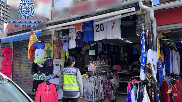 Una agente de la Policía Nacional frente a uno de los comercios investigados.
