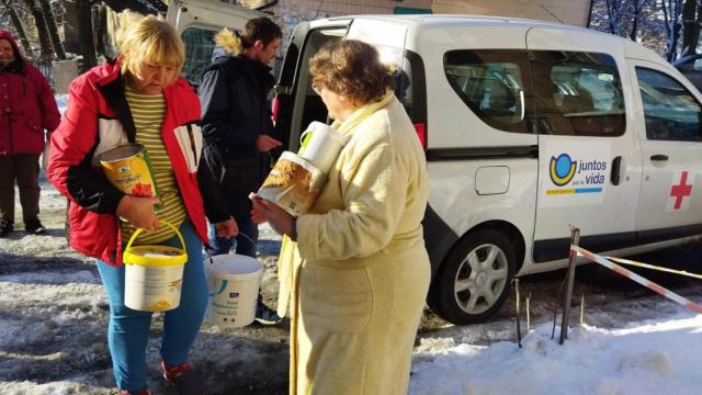 Voluntarios de Juntos por la Vida haciendo entrega de material de ayuda humanitaria.
