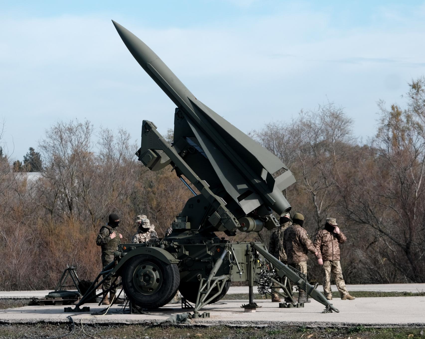 Militares ucranianos (de uniforme claro) y su instructor español, con un lanzador de misiles Hawk en la base de El Copero.