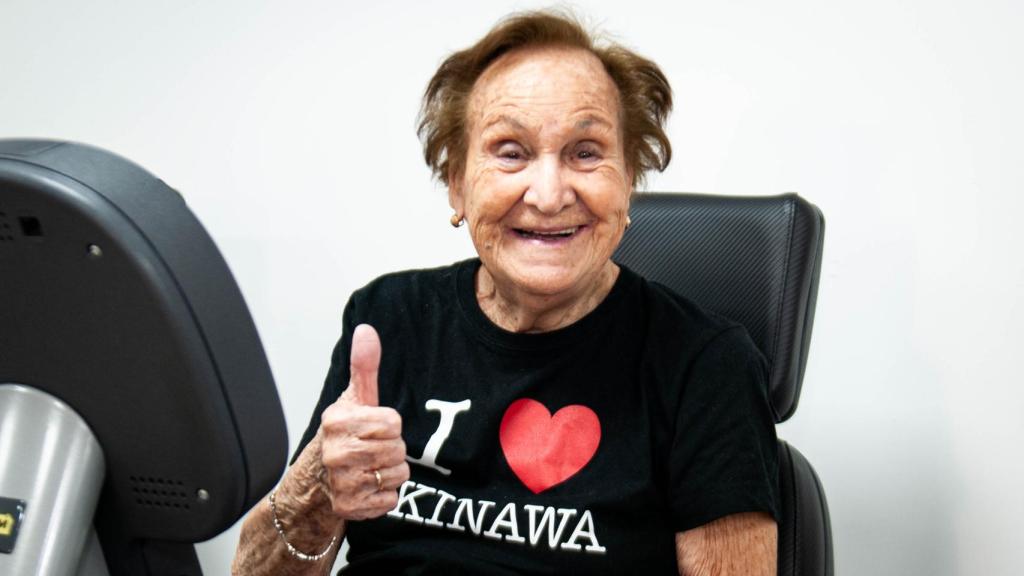 Carmen Miranda sonríe a la cámara desde su bicicleta estática.