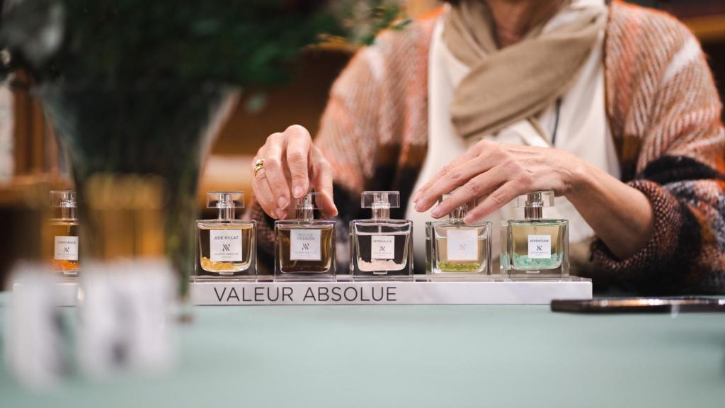 Detalle de las manos de María de la Hera y los perfumes de Valeur Absolue