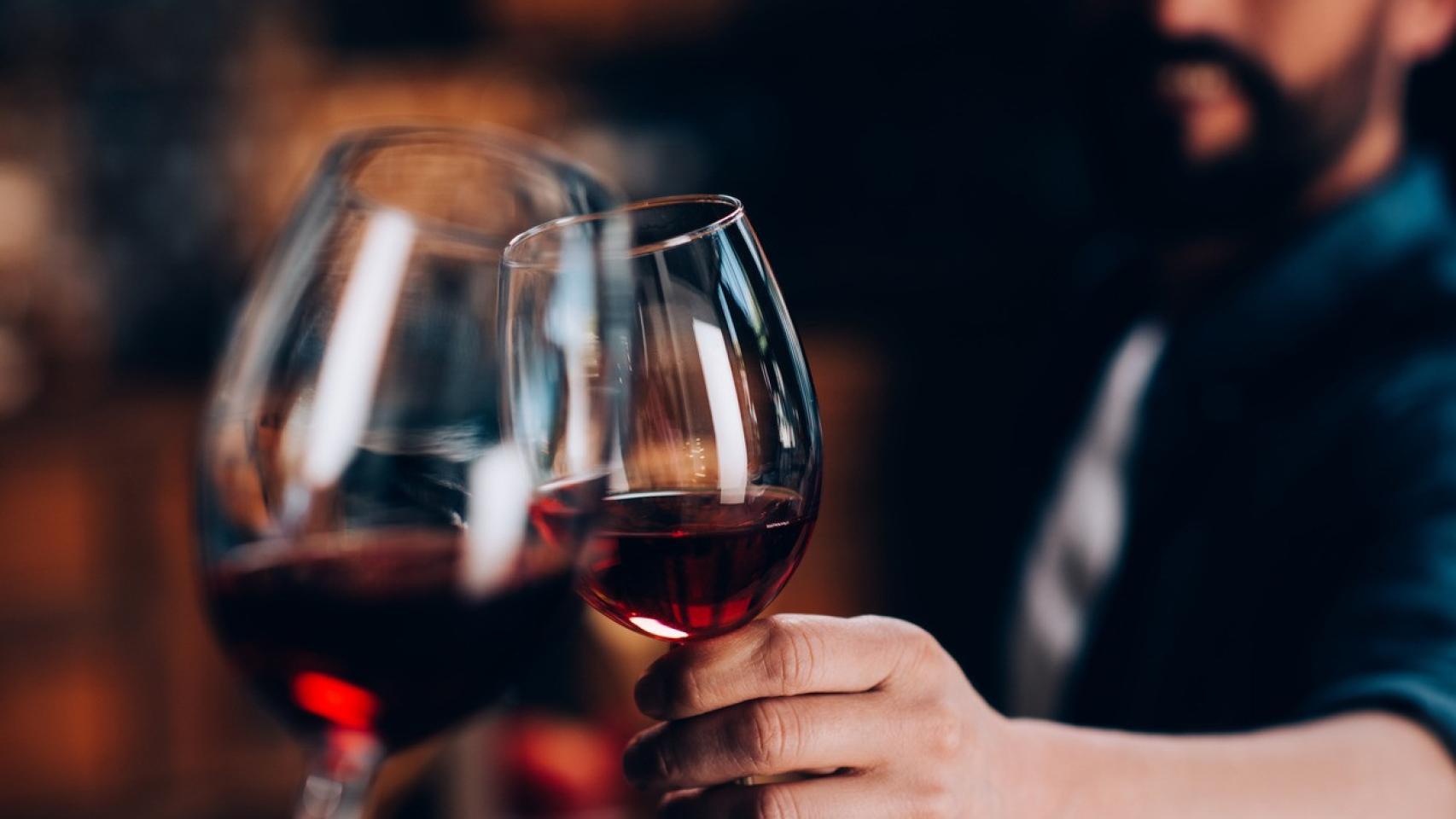 Una pareja brindando con una copa de vino.