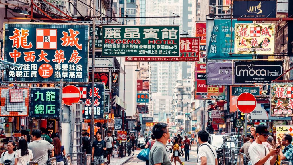 Escena callejera con gente y letreros de neón en Knowloon, Hong Kong.