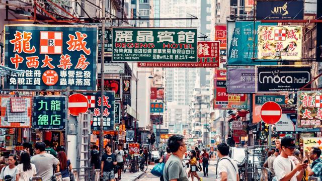 Escena callejera con gente y letreros de neón en Knowloon, Hong Kong.
