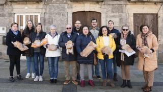 Los panaderos de los 13 'fornos' de la I.G.P. Pan de Cea, con su 'poia' de pan, en la plaza Maior de San Critovo de Cea.