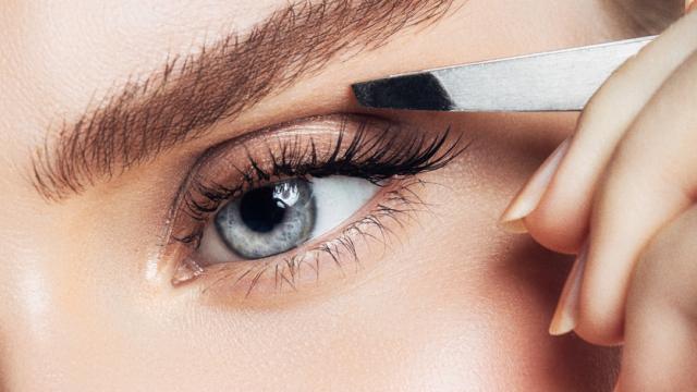 Una mujer, maquillándose.