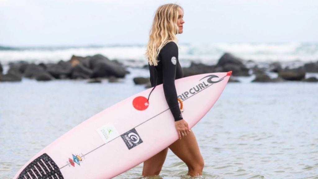Bethany Hamilton con su tabla de surf entrando al agua
