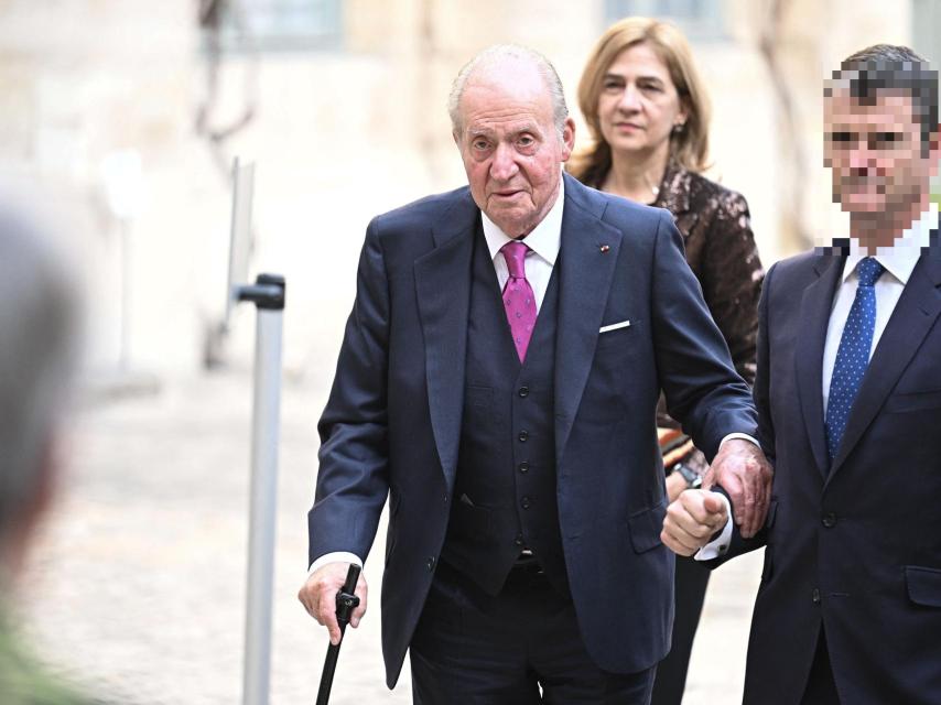 Juan Carlos I, apoyado en su bastón, entrando en el Instituto Francés, seguido de cerca por su hija Cristina.