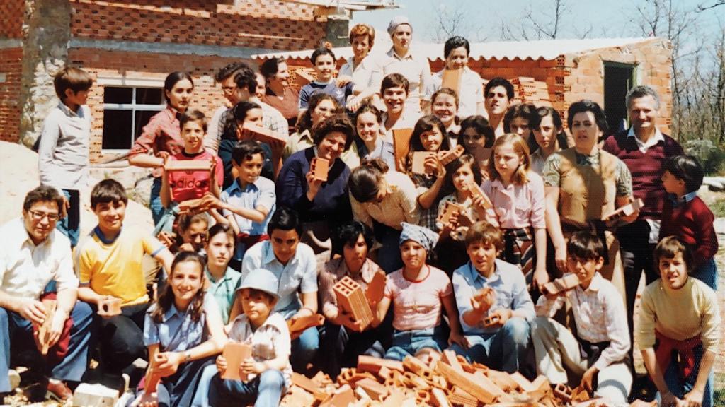 Campistas durante la construcción del albergue, con ladrillos en la mano