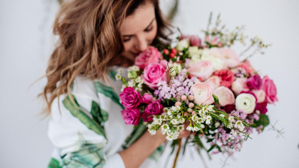 Una mujer sujetando un ramo de flores.