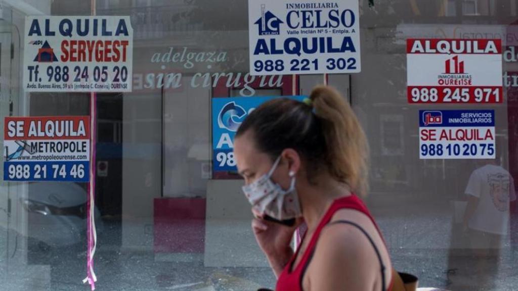 Una joven pasa por delante de una inmobiliaria, en imagen de archivo.
