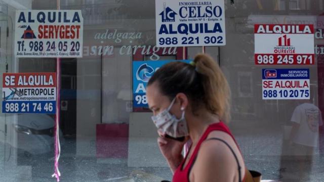 Una joven pasa por delante de una inmobiliaria, en imagen de archivo.