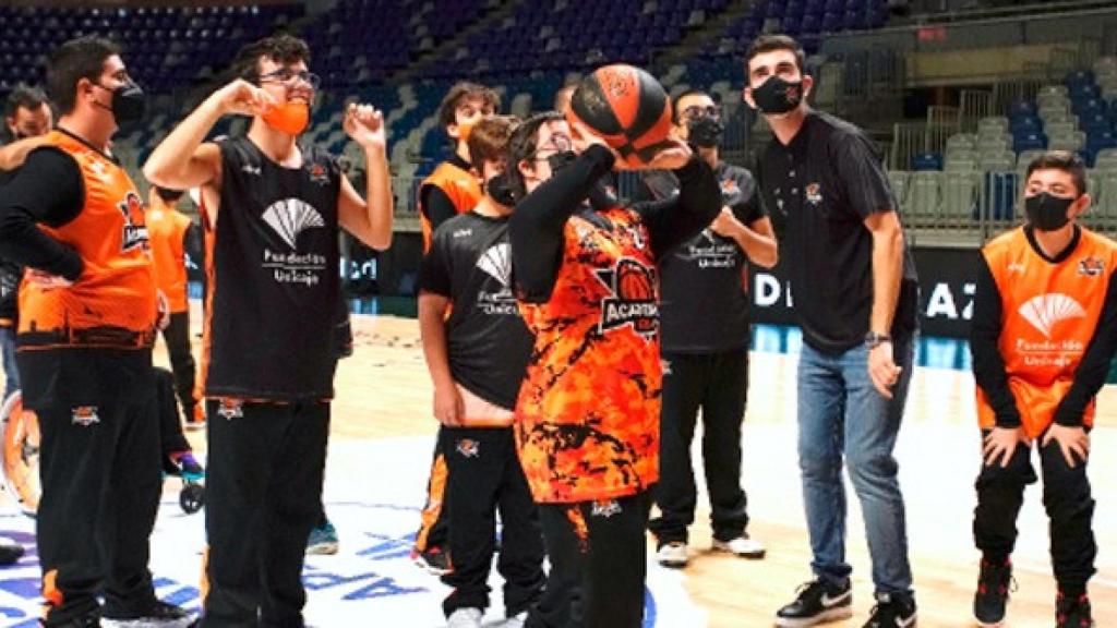 Lanzamiento a canasta por parte de varios niños.