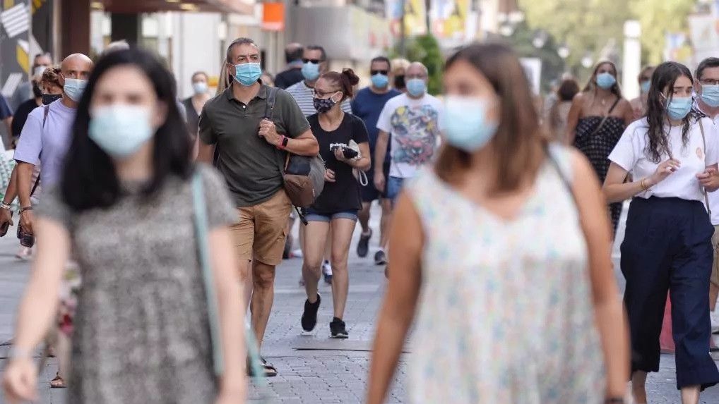 Varias personas por la calle con mascarilla durante la pandemia.