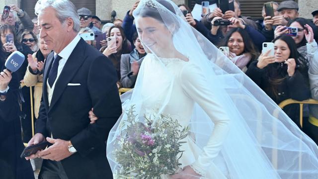 Carlos Sainz, padre y padrino, llegando a la iglesia del brazo de su hija menor, Ana, este sábado en Cebreros (Ávila).