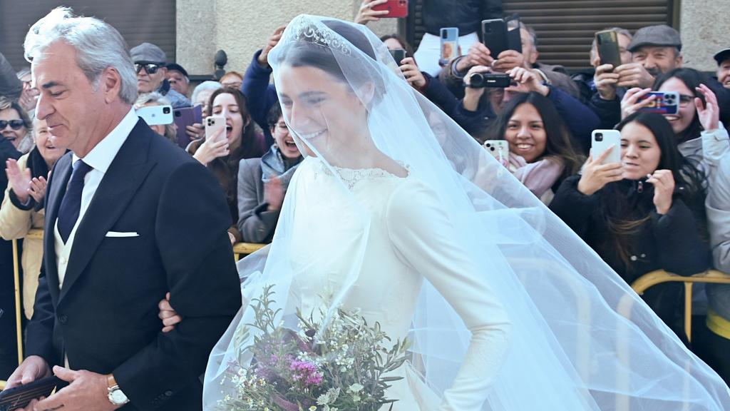 Carlos Sainz, padre y padrino, llegando a la iglesia del brazo de su hija menor, Ana, este sábado en Cebreros (Ávila).