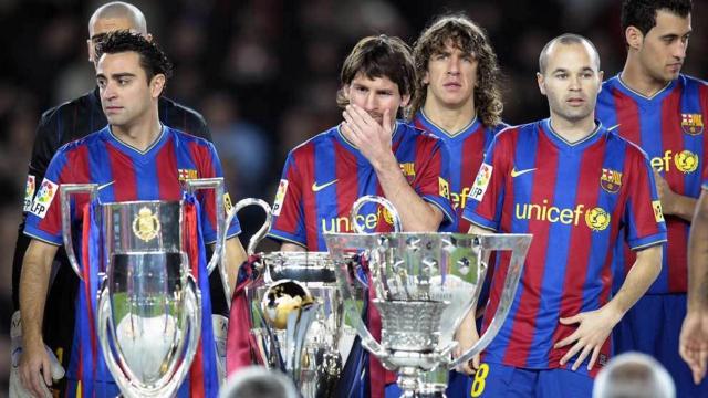 Xavi Hernández, Leo Messi y Andrés Iniesta posan detrás del triplete de títulos conseguido por el Barça de Guardiola en 2009.