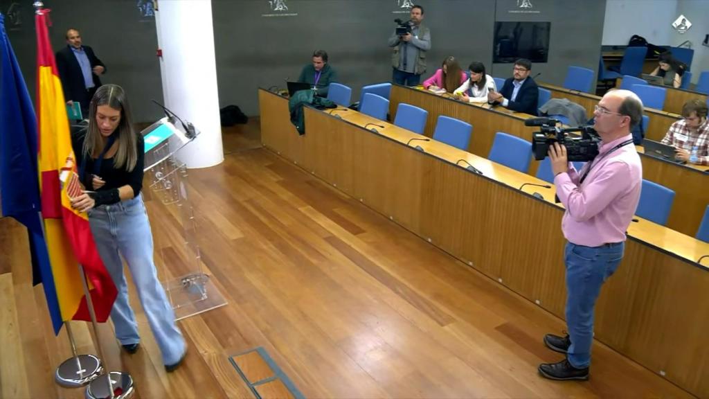 La diputada mientras retira la bandera de España.
