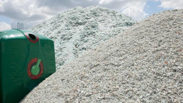 Imagen de archivo una montaña de calcín junto a un contenedor verde.