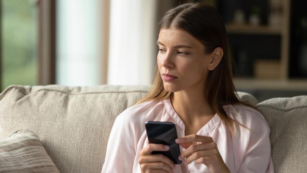 Una mujer, consultando su móvil.