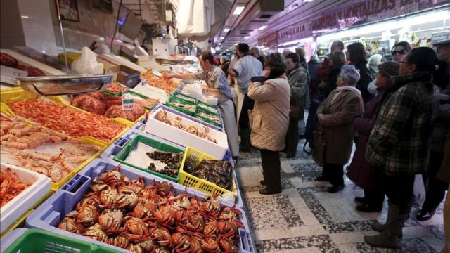 Un grupo de consumidores esperando a ser atendidos en una pescadería.