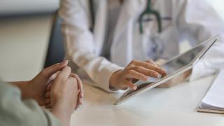 Imagen de archivo de un médico de cabecera atendiendo a un paciente.