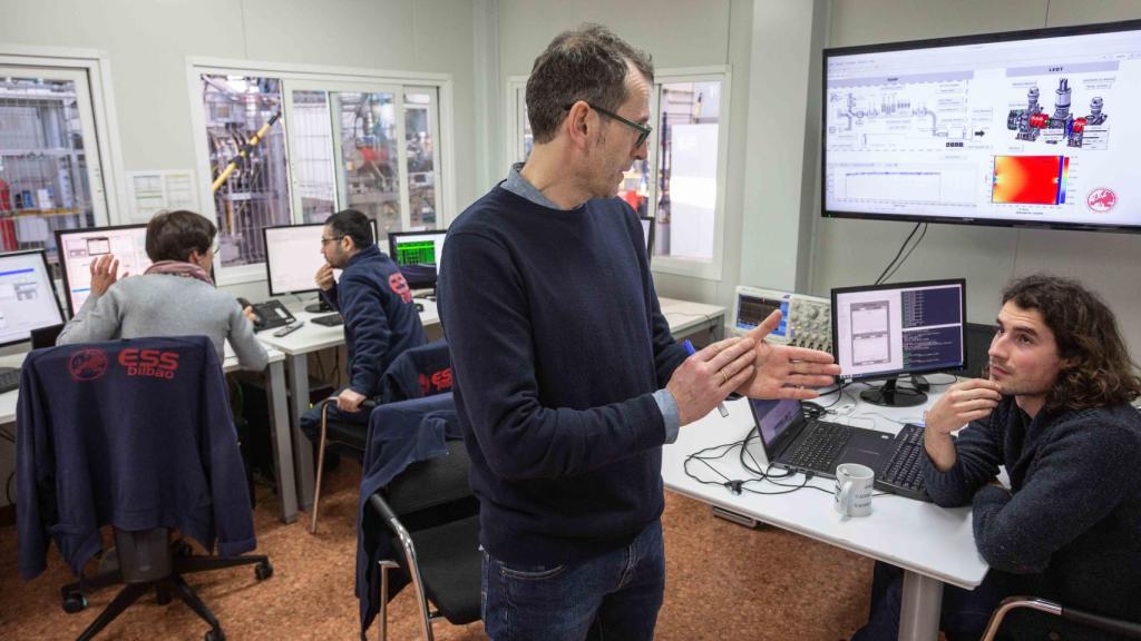 Ibon Bustinduy, jefe de división del acelerador (de pie), en la sala de control de la fuente de iones
