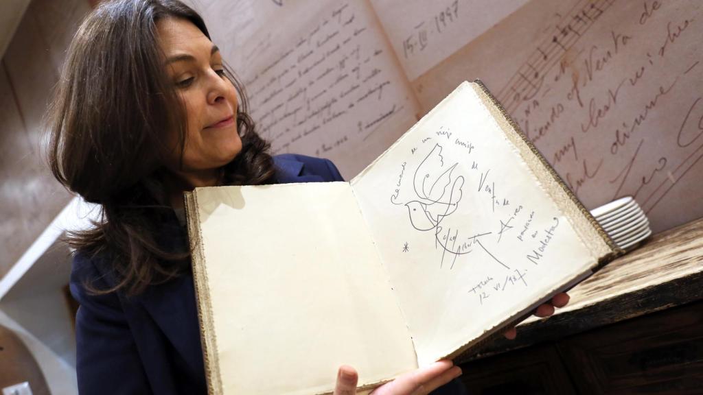 Cuca Díaz de la Cuerda muestra la firma de Rafael Alberti en el libro de honor del restaurante.