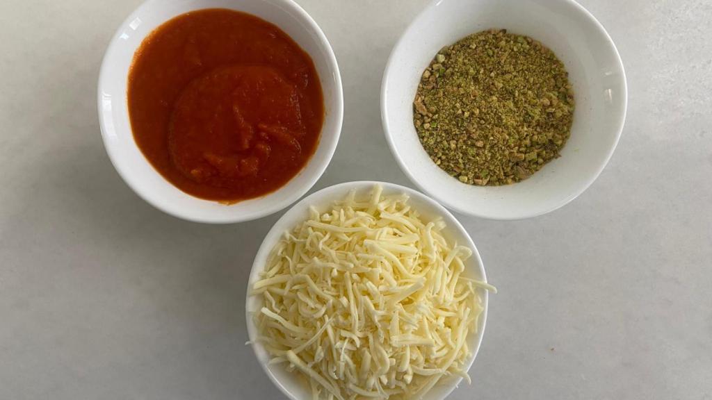 Salsa de tomate casera, pistachos picados y mozzarella.