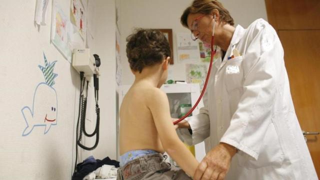 Una pediatra atiende a un niño en su consulta