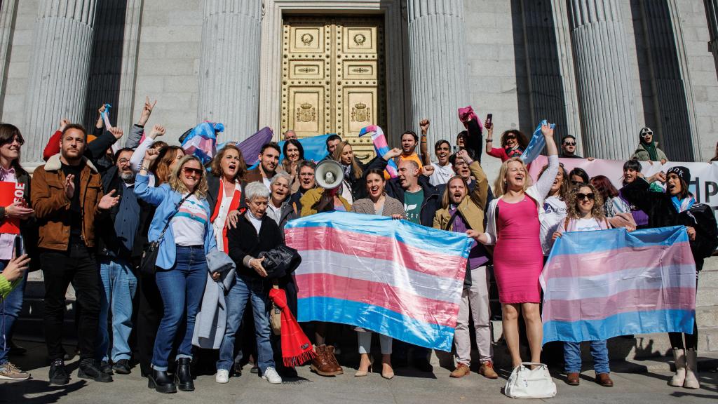 Irene Montero junto a activistas por la Ley Trans junto a la bandera del movimiento.