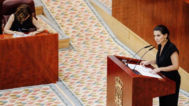 La portavoz de Vox en la Asamblea de Madrid, Rocío Monasterio, interviene en una sesión plenaria en la Asamblea de Madrid con Ayuso de fondo.