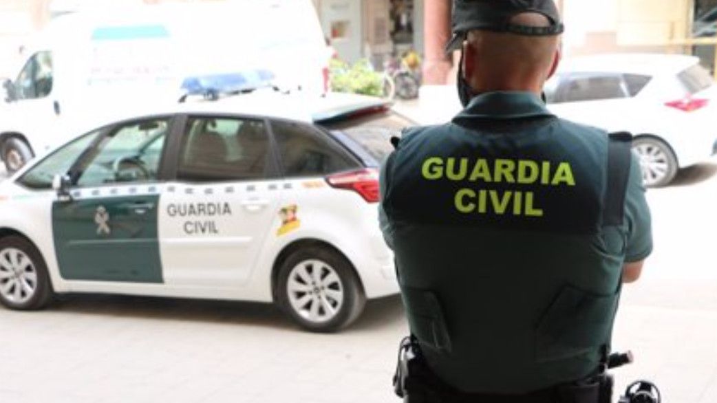 Agente y vehículo de la Guardia Civil.