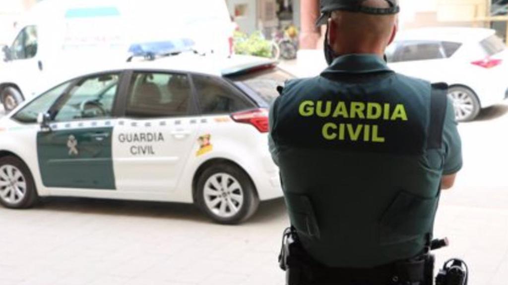 Agente y vehículo de la Guardia Civil.