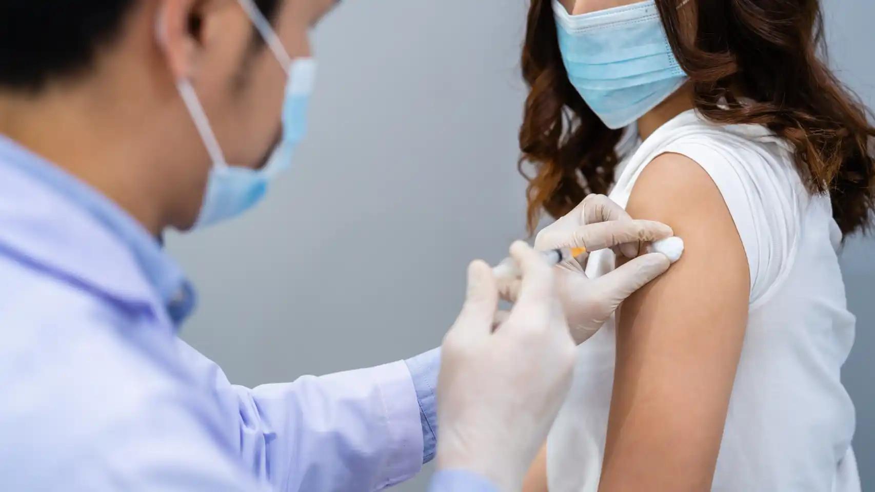 Un sanitario vacuna a una paciente contra el Covid.