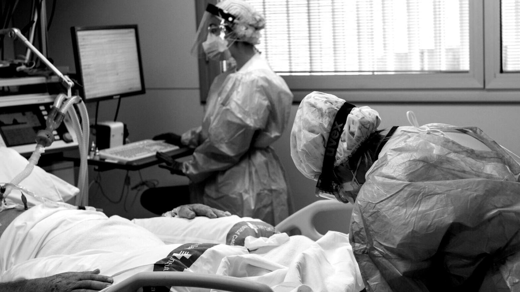Personal sanitario atendiendo a un paciente en la UCI.