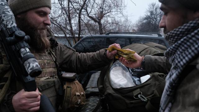 Uno de los francotiradores ayuda al médico a preparar el equipo sanitario para cargarlo en los vehículos.
