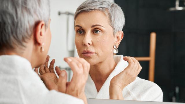 Una mujer, mirándose al espejo.
