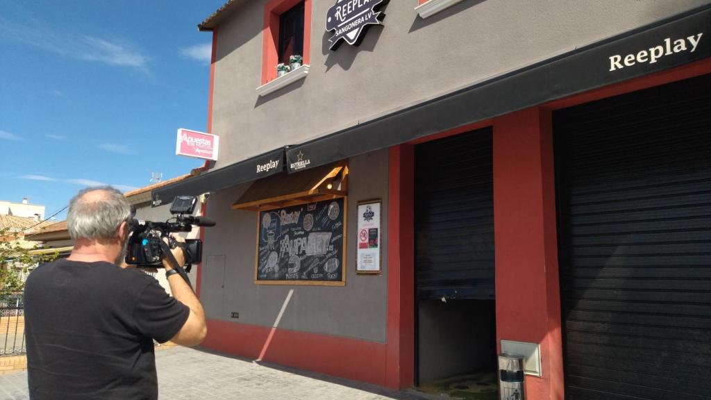 Un cámara de televisión, este martes, grabando la puerta del salón de juego que fue forzada por la 'banda del Porsche' en Sangonera la Verde.